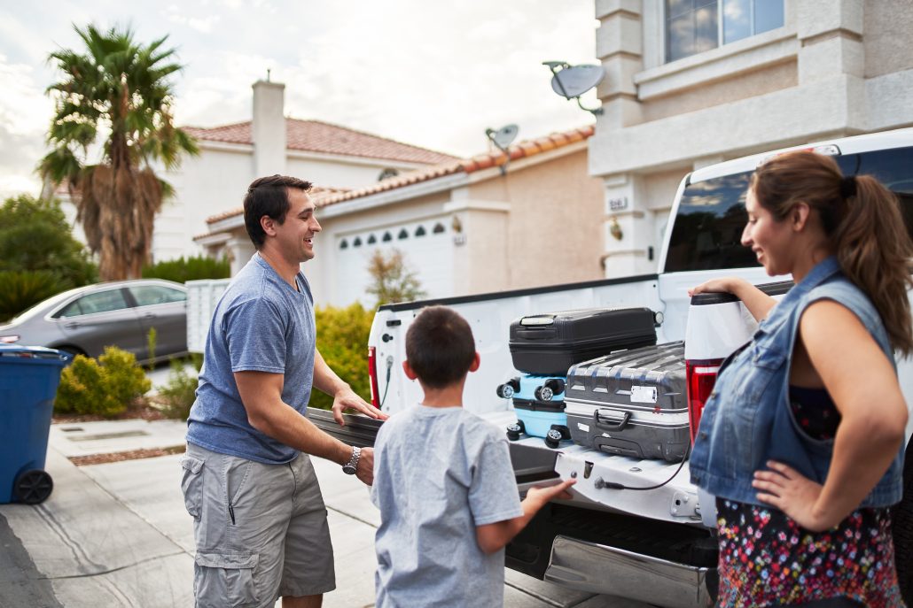 Family loading luggage into a truck.