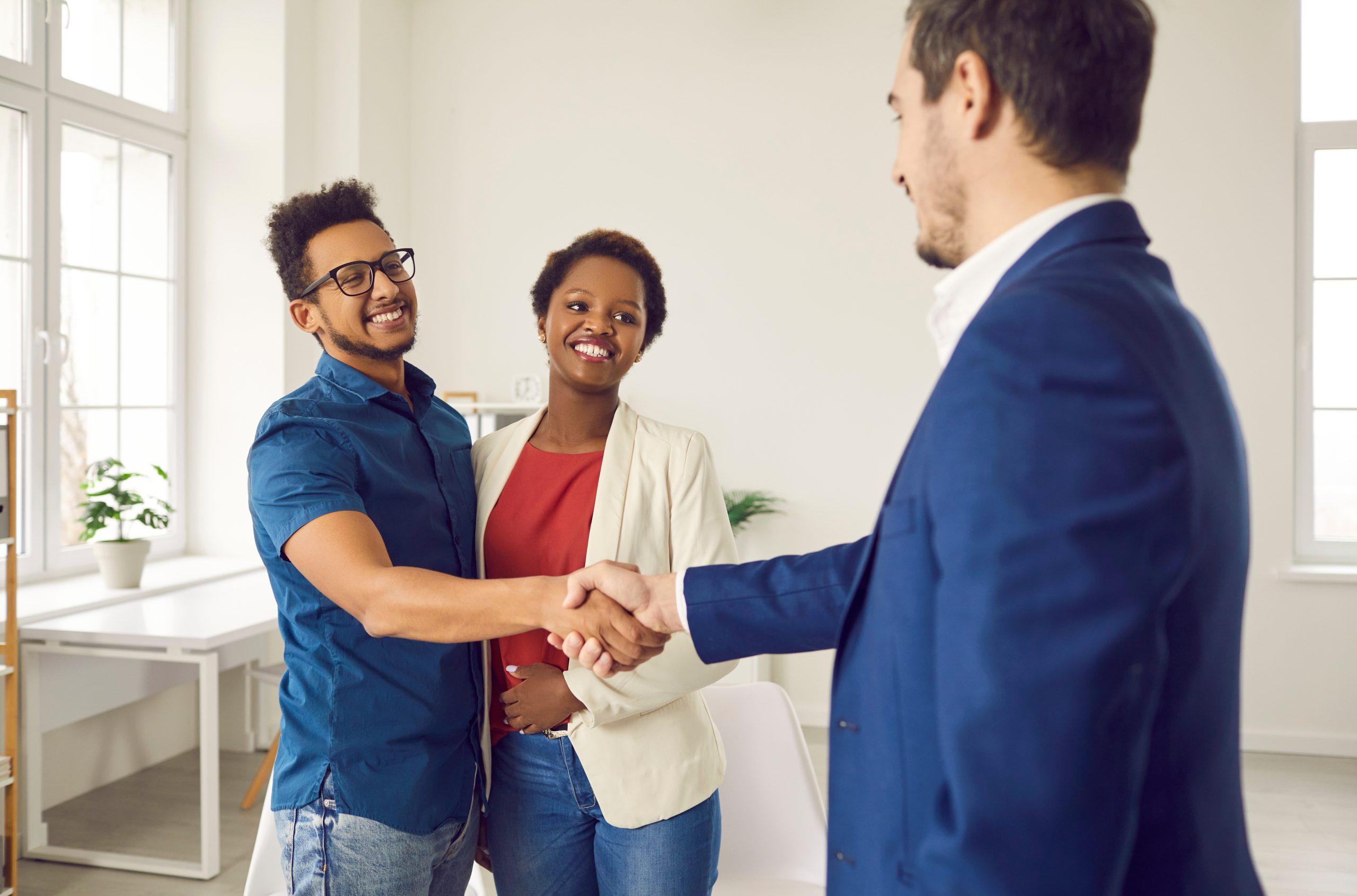 Black couple shaking hands with loan broker.